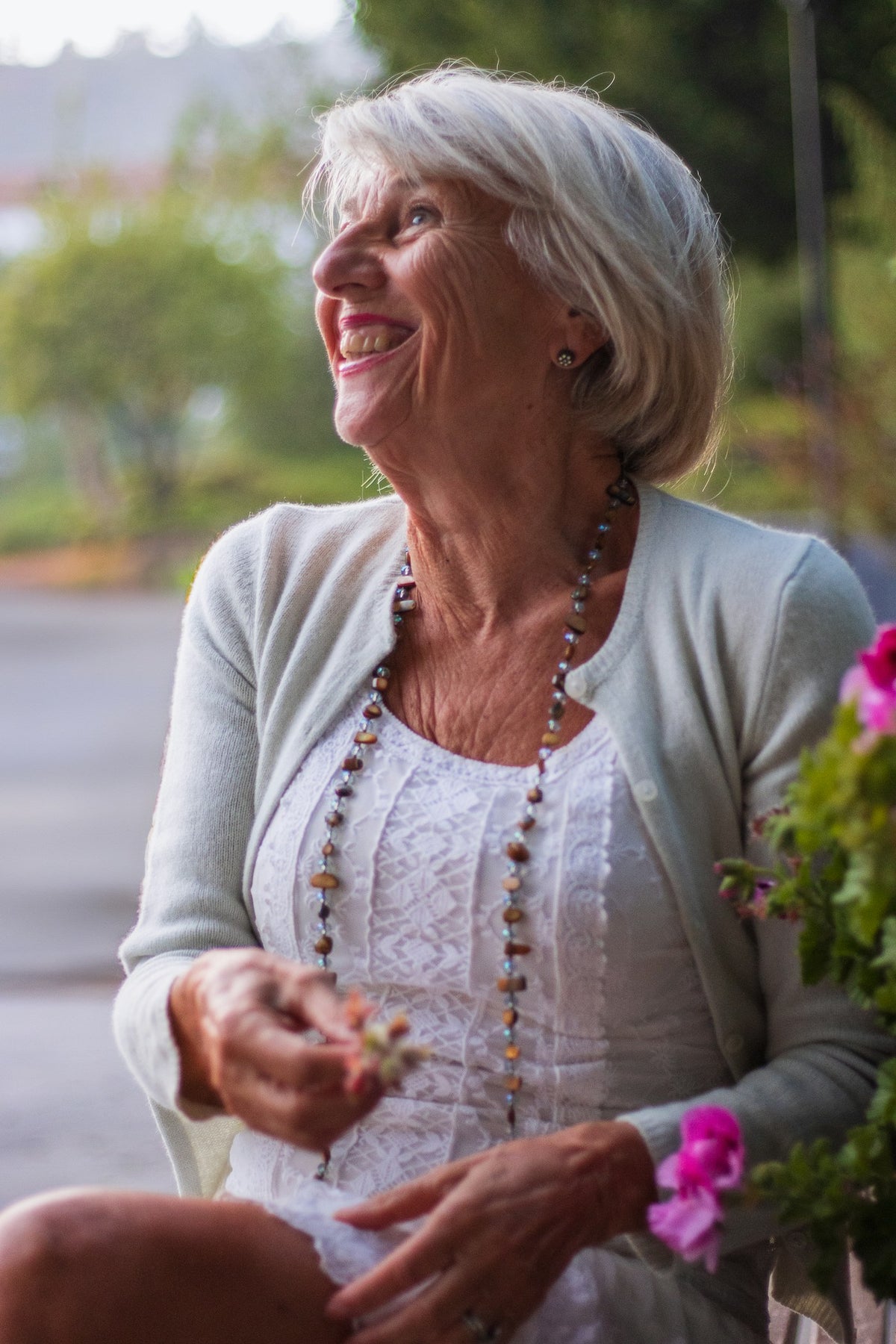 Smiling woman with silver hair in a light cardigan